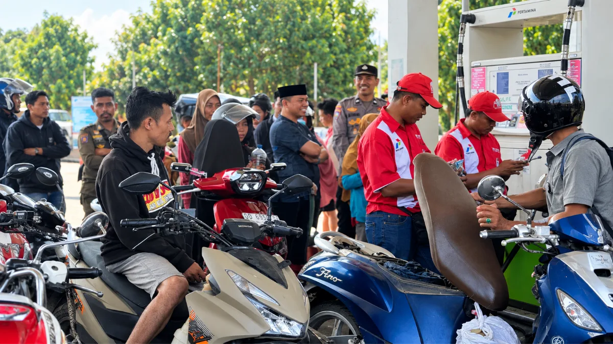 Nur Alim Rukman membagikan air minum kepada warga yang mengantre BBM di Takalar